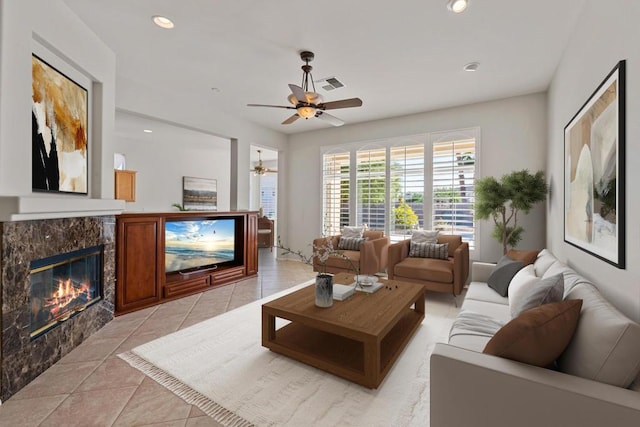 living room featuring ceiling fan, light tile patterned floors, and a fireplace