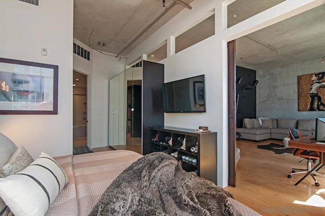 bedroom with a high ceiling and hardwood / wood-style flooring