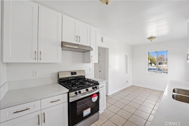 kitchen featuring gas stove, white cabinets, and light tile patterned floors