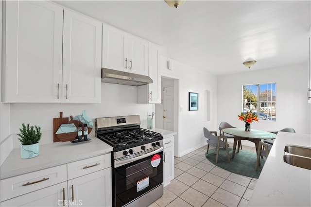 kitchen with gas stove, white cabinetry, and light tile patterned floors