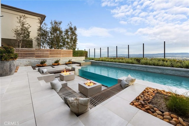 view of pool featuring a patio area and a fire pit