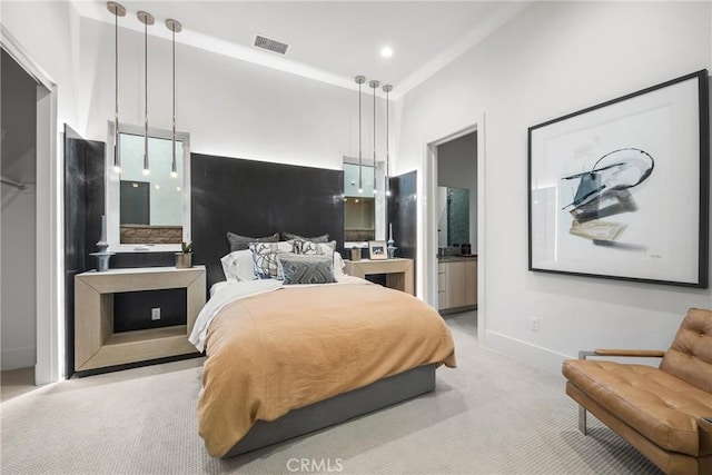 bedroom with connected bathroom and light colored carpet