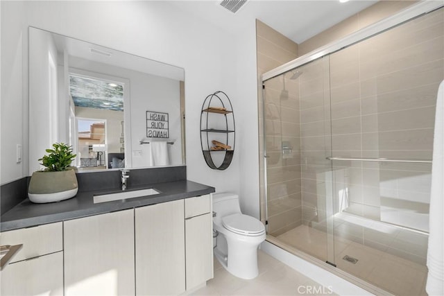 bathroom with tile patterned floors, a shower with door, vanity, and toilet