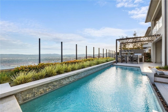 view of pool with area for grilling and a water view