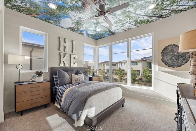 bedroom featuring multiple windows, ceiling fan, and light colored carpet