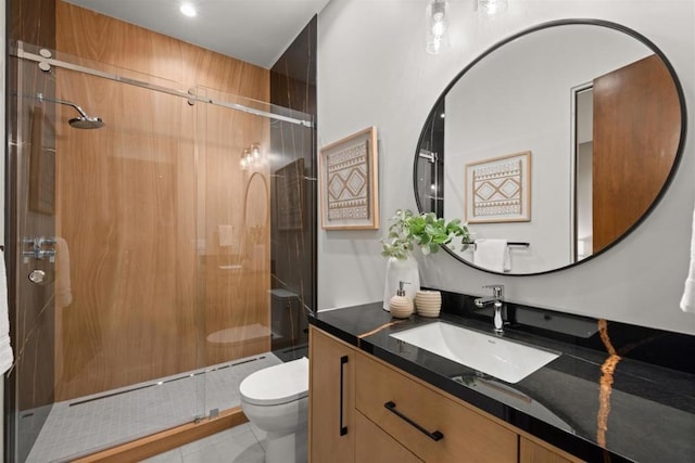 bathroom featuring vanity, a shower with shower door, tile patterned floors, and toilet