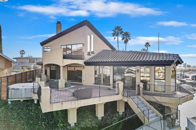 rear view of house featuring a hot tub