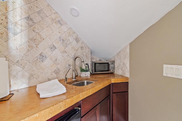 kitchen featuring wood counters, backsplash, and sink