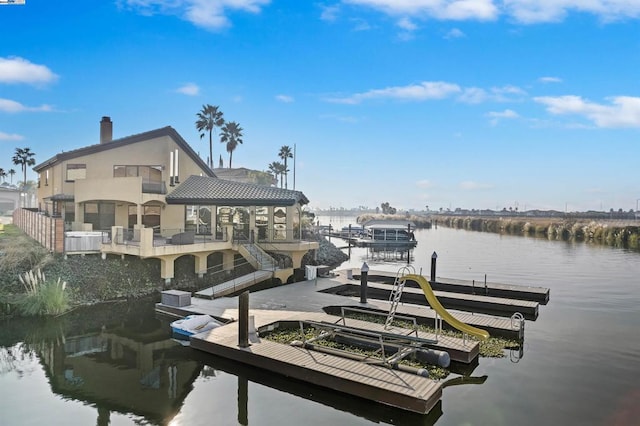 dock area with a water view and a balcony