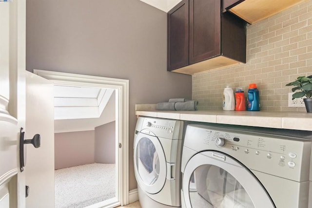 laundry room with washer and dryer and cabinets