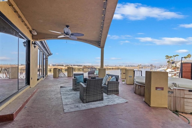 view of patio / terrace with ceiling fan and a hot tub