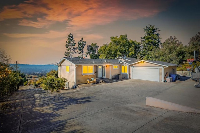 ranch-style house featuring a garage and cooling unit