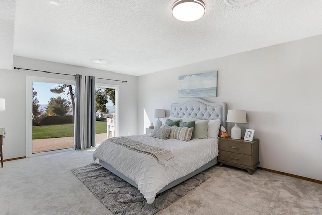 carpeted bedroom with access to exterior and a textured ceiling