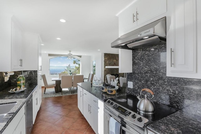 kitchen featuring appliances with stainless steel finishes, decorative backsplash, tile patterned floors, and white cabinetry