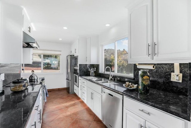 kitchen with dark stone counters, sink, stainless steel appliances, and white cabinetry