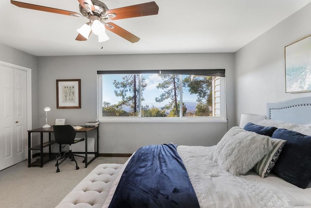 carpeted bedroom featuring ceiling fan and a closet