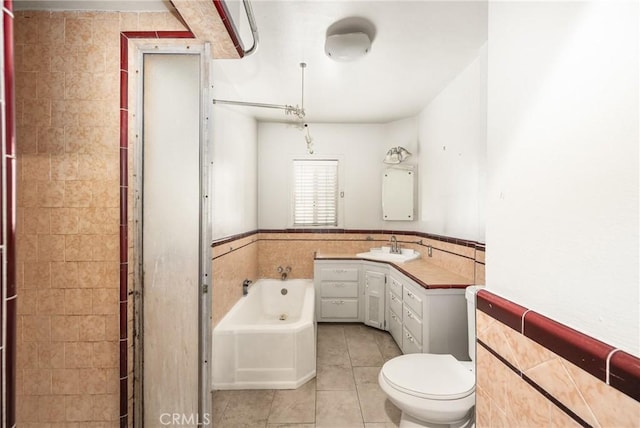 bathroom featuring tile patterned flooring, a bathtub, toilet, and tile walls