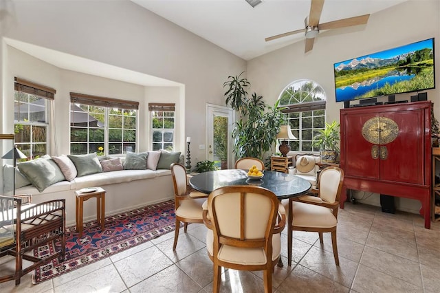 tiled dining area featuring ceiling fan and lofted ceiling