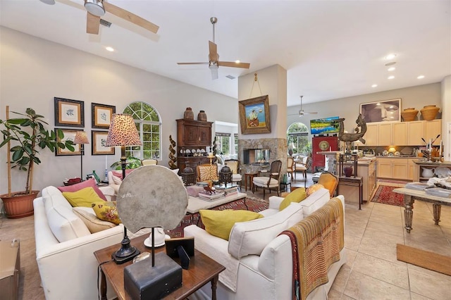 living room featuring a fireplace, light tile patterned floors, and a high ceiling