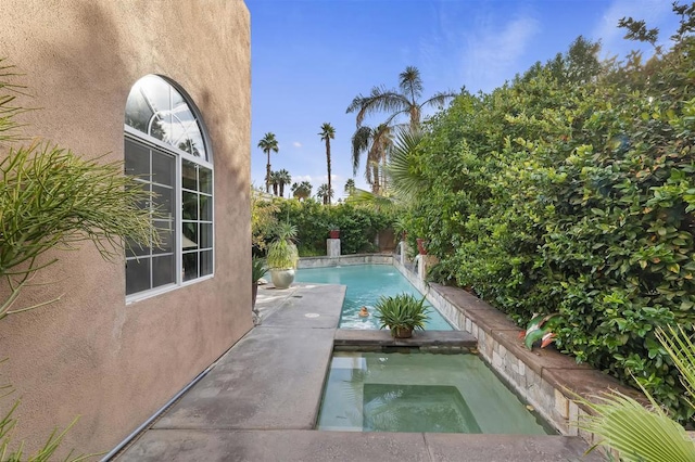 view of pool with an in ground hot tub