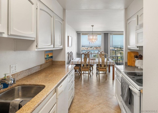 kitchen with white appliances, sink, hanging light fixtures, white cabinetry, and a chandelier