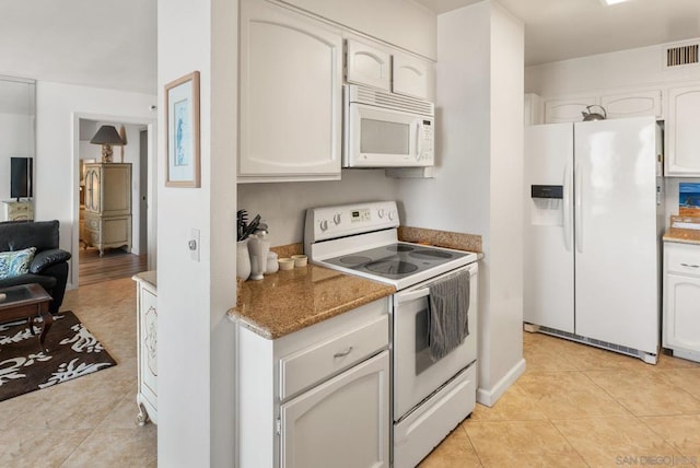 kitchen with white cabinetry, light tile patterned flooring, and white appliances