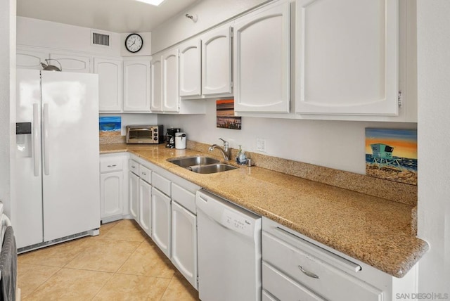 kitchen featuring white appliances, white cabinets, sink, light tile patterned floors, and light stone counters