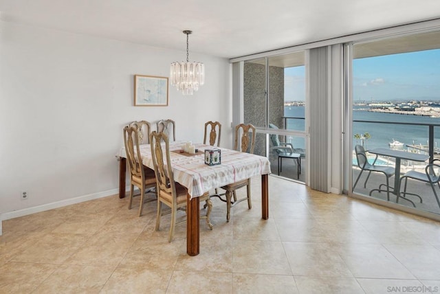 tiled dining room with a chandelier, a water view, and a wall of windows