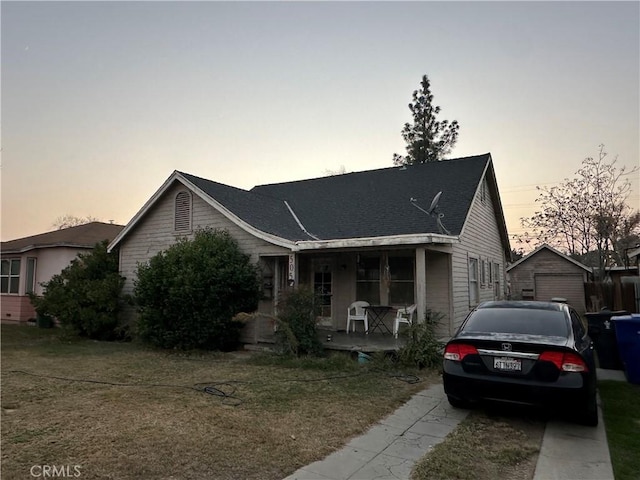 view of front of property with a lawn, covered porch, and a garage