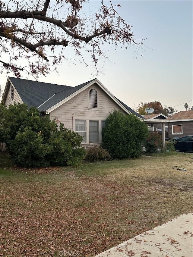 property exterior at dusk with a yard