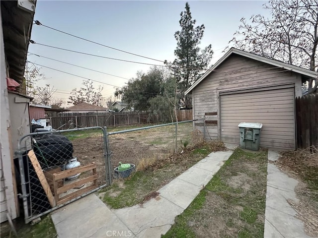 yard at dusk featuring a garage and an outdoor structure