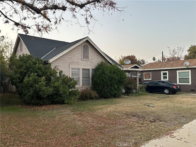 property exterior at dusk featuring a yard