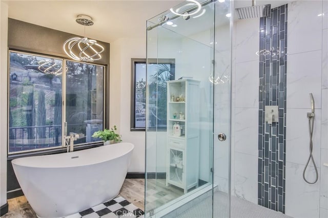 bathroom featuring an inviting chandelier, wood-type flooring, and separate shower and tub