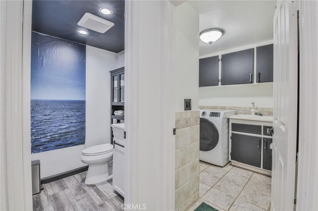 laundry room featuring sink, washer / dryer, and a water view