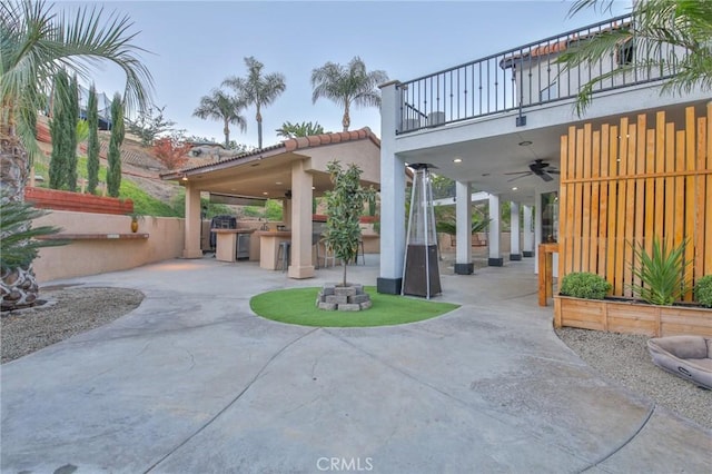 view of patio with ceiling fan, a balcony, exterior kitchen, and an outdoor bar