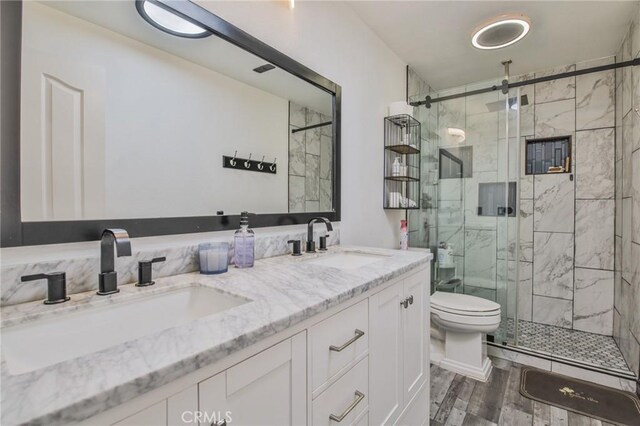 bathroom featuring vanity, toilet, and walk in shower