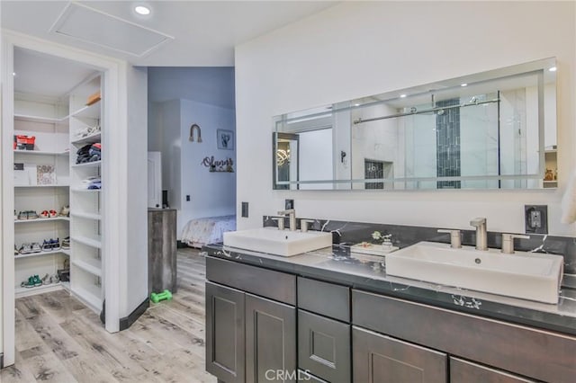 bathroom with hardwood / wood-style floors, walk in shower, and vanity