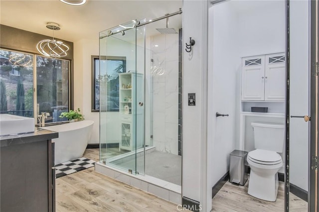 full bathroom with toilet, shower with separate bathtub, hardwood / wood-style flooring, and a notable chandelier