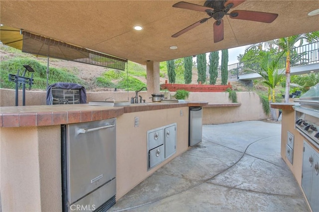 view of patio with ceiling fan, sink, and area for grilling