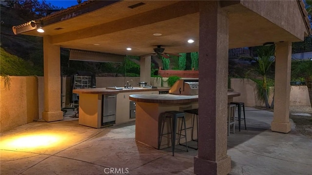 view of patio with grilling area, ceiling fan, area for grilling, and a bar