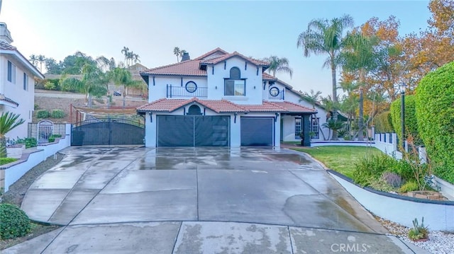 mediterranean / spanish-style house with a front lawn, a balcony, and a garage