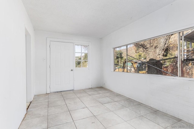 tiled empty room with a textured ceiling