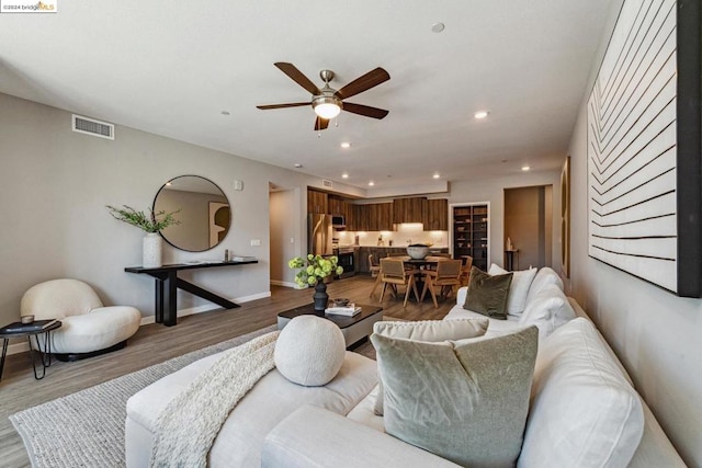 living room featuring hardwood / wood-style flooring and ceiling fan