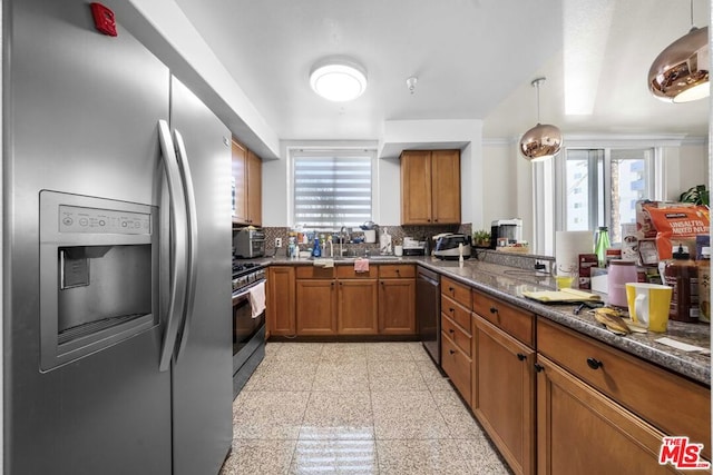 kitchen featuring backsplash, hanging light fixtures, sink, appliances with stainless steel finishes, and plenty of natural light