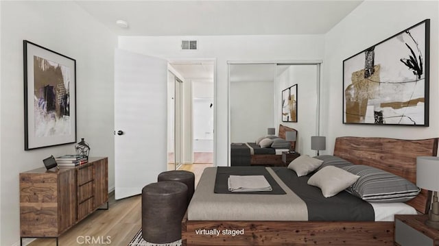 bedroom with light wood-type flooring and a closet