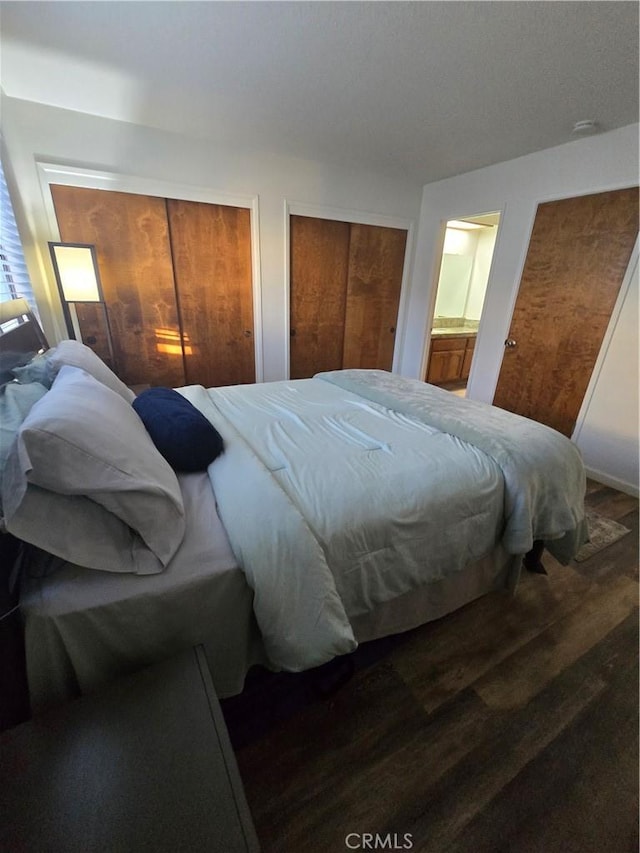 bedroom with hardwood / wood-style floors and multiple closets