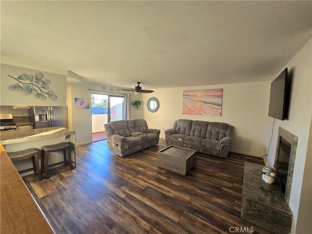 living room featuring ceiling fan and dark wood-type flooring