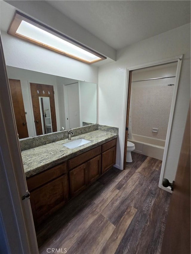 full bathroom with toilet, shower / bath combination, wood-type flooring, and vanity