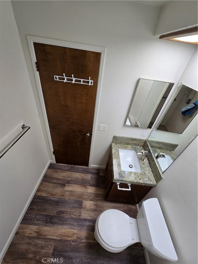 bathroom featuring toilet, vanity, and wood-type flooring