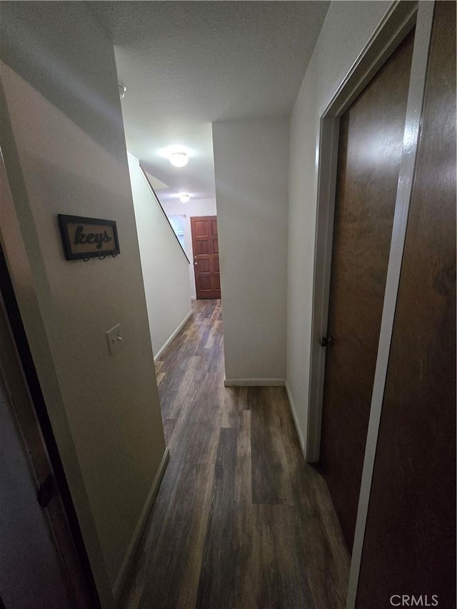 corridor with dark hardwood / wood-style flooring